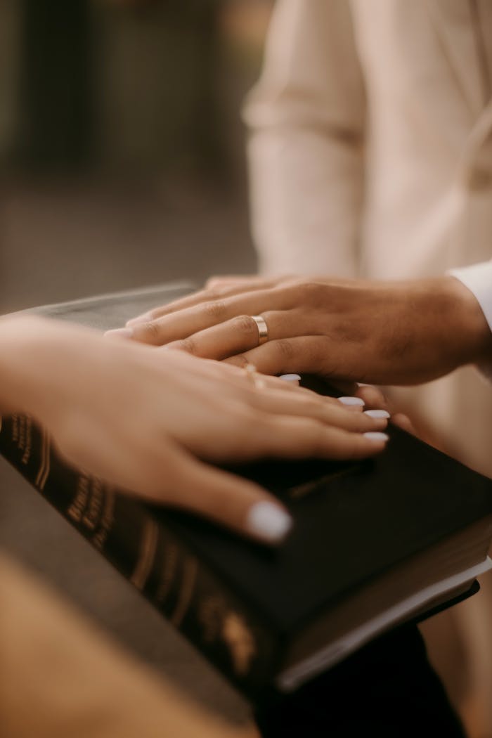 Close-Up of Hands on Bible During Ceremony